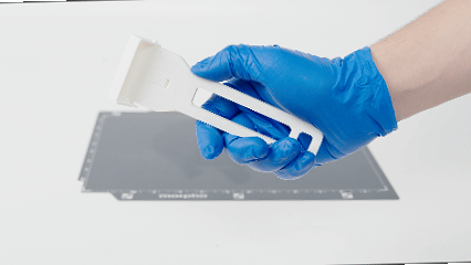 Removing cured ink from the A4 Tray with a plastic scraper